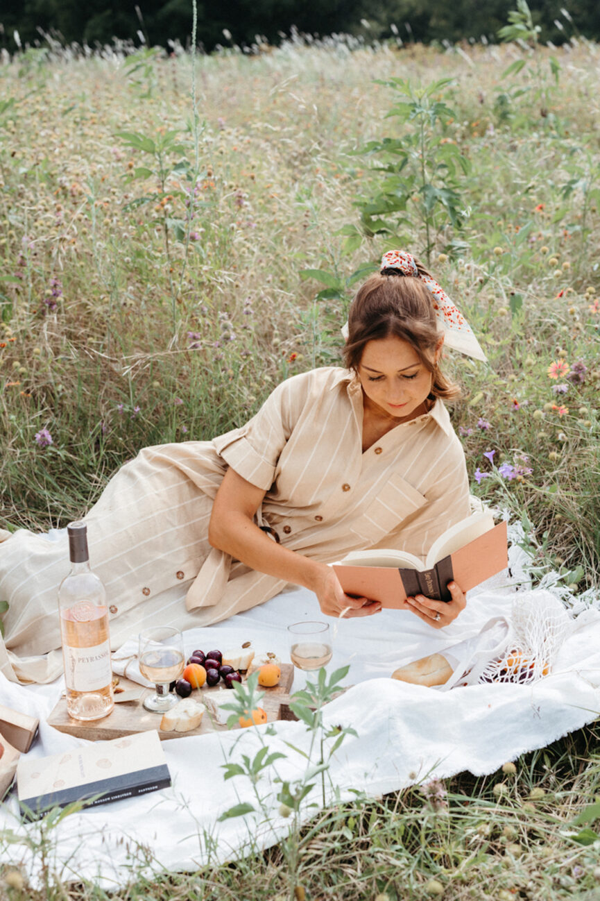 Woman reading on picnic blanket.